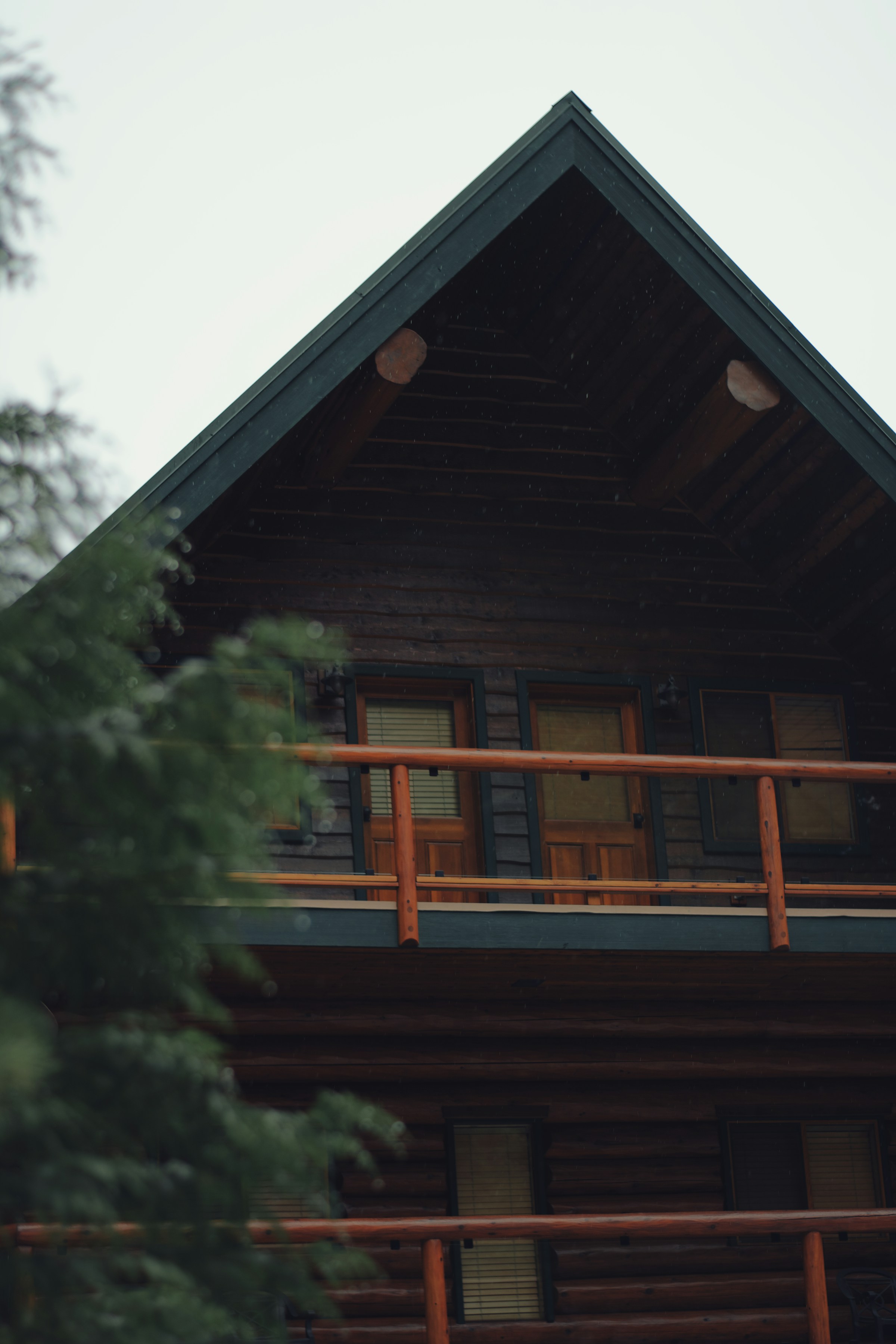 A large timber lodge with balconies set among evergreens in the mountains near Whistler